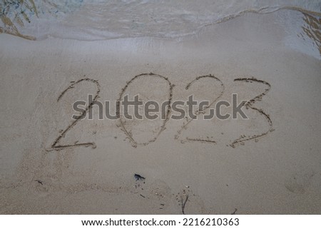 heart on the sand On the fine sand write the number 2023 new year 2023 .