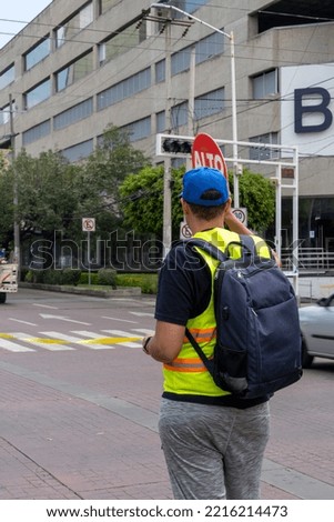 person with a high traffic sign with reflective vest, guadalajara, mexico
