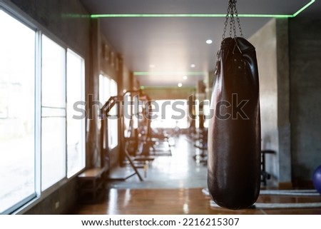 Punch bag at fitness center club with training exercise boxing sandbag. Modern gym interior with equipment. Workout with sport boxer for training or burn callories the for sport boxing concept. Royalty-Free Stock Photo #2216215307