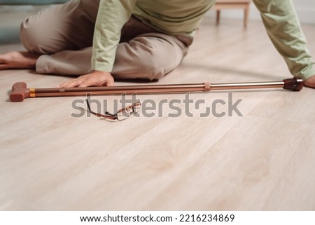 Asian senior man falling on the ground with walker in living room at home. Elderly older mature male having an accident heart attack for emergency help support from hospital. Insurance health care. Royalty-Free Stock Photo #2216234869