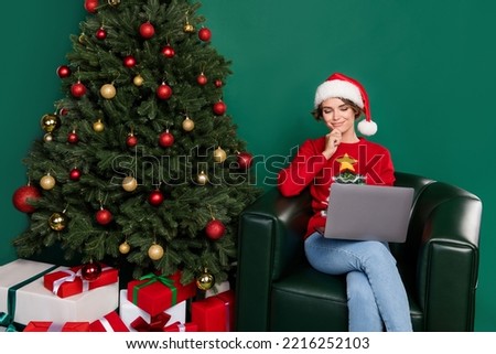 Portrait of positive pretty girl sit leather chair use netbook hand touch chin isolated on green color background