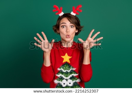 Photo of impressed funky lady wear red sweater horns hair band rising arms isolated green color background