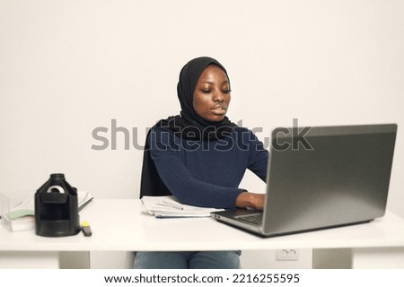 Arabic entrepreneur working on a laptop in her office