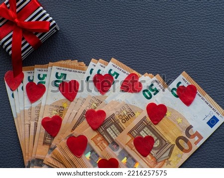 Euro money and red hearts for background. The concept of cash costs for the purchase of gifts for Valentine's Day, love and money. Shopping, prices, sales, discounts, holiday gifts, congratulations.