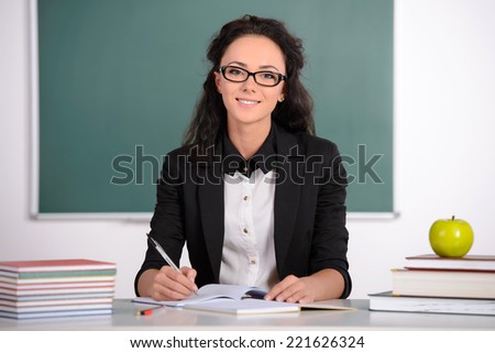 Young smiling student or teacher at the blackboard