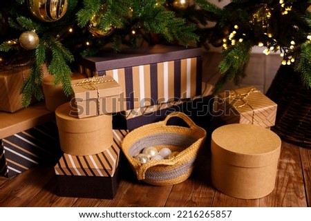 christmas gift in a cardboard box on a brown wooden floor near a new year tree