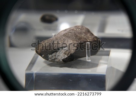A sample piece of Chiang Khan chondrites meteorite stone. 
view through magnifying glass.