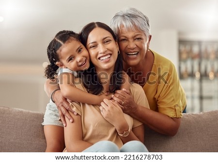Grandmother, mom and child hug in a portrait for mothers day on a house sofa as a happy family in Colombia. Smile, mama and elderly woman love hugging young girl or kid and enjoying quality time Royalty-Free Stock Photo #2216278703