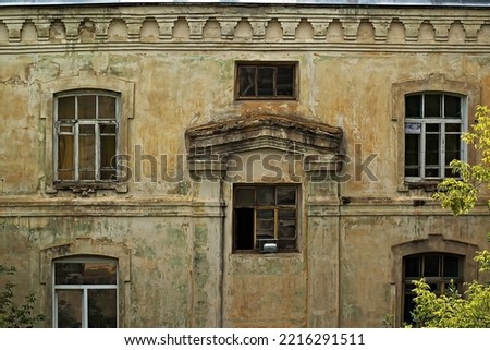 wall of an old house with peeling plaster. the house was built during the time of tsarist russiawall of an old house with peeling plaster. the house was built during the time of tsarist russia.