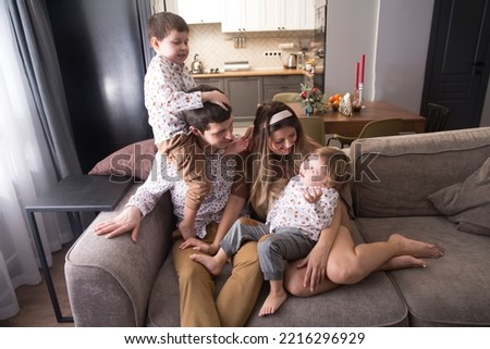 family has fun spending time together at home. mom, dad and two child son play, hugging and having fun together at home. Christmas time. 