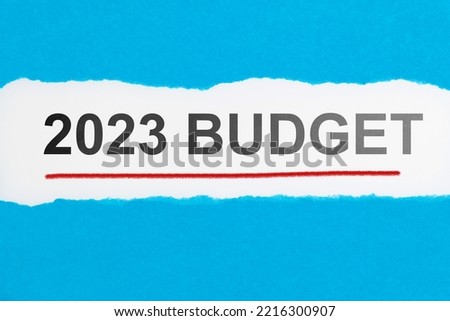 Torn blue paper with space writing 2023 budget