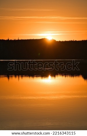Sunset with reflection on a Swedish lake in Smalland. Romantic evening mood. Landscape shot from Scandinavia in nature