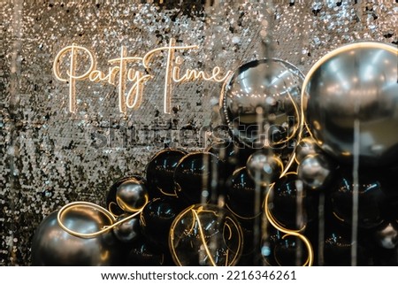 A place for congratulations for birthday. Arch or photo booth decorated black and silver balloons and led strips. Zone with decor sparkling sequins for wedding. Text party time. Happy New Year 2023. Royalty-Free Stock Photo #2216346261