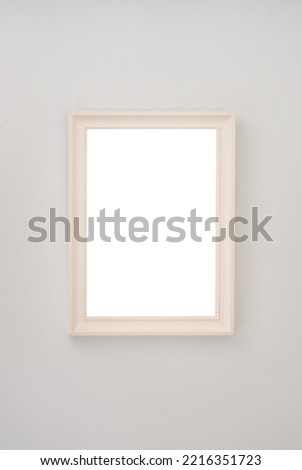 Beige empty photo frame hanging on the wall. High quality photo