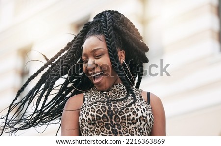 Hair, freedom and fashion with a fun black woman in the city on a summer day feeling cheerful or carefree. Braids, free and trendy with a young female in town on an urban background with flare Royalty-Free Stock Photo #2216363869