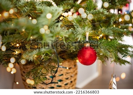 Modern design Christmas tree decorated with balls and garlands - navy red,grey, silver. Winter holidays composition. Close up. Beautifully decorated Christmas tree in a wicker basket with bright balls