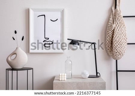 Aesthetic interior of living room with mock up poster frame, white wall, round black coffee table, vase with dried flowers and elegant personal accessories. Stylish home decor. Template.