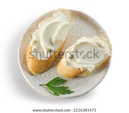 baguette slices with cream cheese on plate isolated on white background, top view Royalty-Free Stock Photo #2216381471