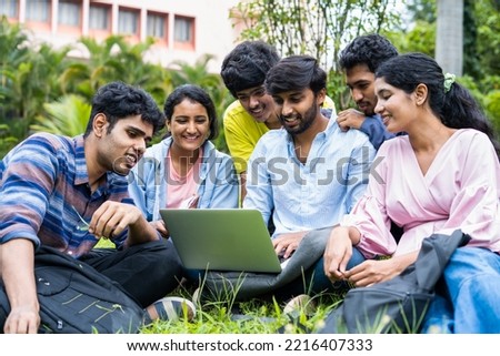 group of young students checking exam results or waiting for project approval on laptop at collage campus - concept of teamwork, bonding and friendship. Royalty-Free Stock Photo #2216407333