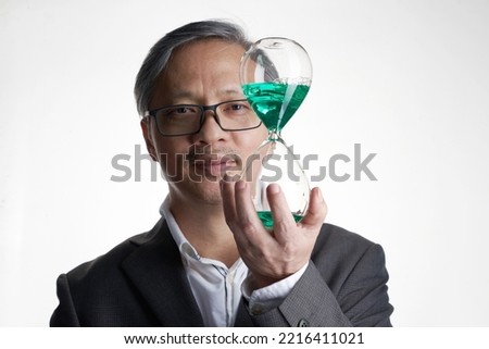 chinese businessman  holding hour glass against white background           