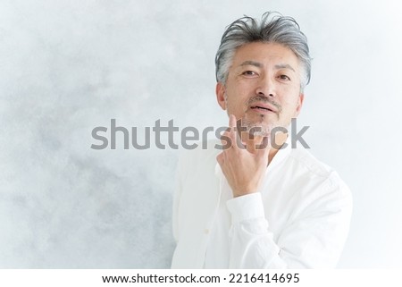 middle aged asian man checking jaw beard Royalty-Free Stock Photo #2216414695