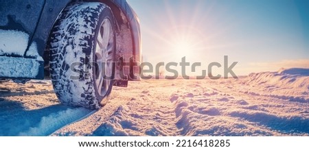 Closeup view of the car's wheel on the snowy road in natural park Royalty-Free Stock Photo #2216418285