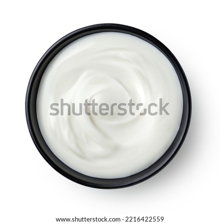 Black ceramic bowl of fresh greek yogurt isolated on white background, top view