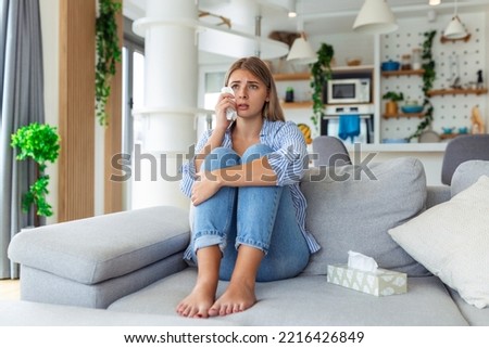 Unhappy young woman covering face with hands, crying alone close up, depressed girl sitting on couch at home, health problem or thinking about bad relationships, break up with boyfriend, divorce Royalty-Free Stock Photo #2216426849