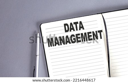DATA MANAGEMENT word on notebook with pen