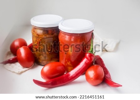 canned red peppers in a glass jar on a white background. High quality photo