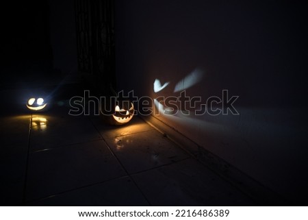 Halloween horror concept with glowing pumpkin. Halloween evil pumkins smilin faces in dark . Selective focus. Long exposure shot