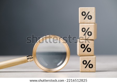 Magnifying glass and stack of wood cubes with percentage icon Royalty-Free Stock Photo #2216512825
