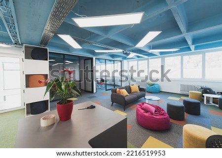 Interior of cozy light boardroom with table, modern stylish chairs and desktop computer, all ready for corporate meeting. Empty spacious office of business company or creative coworking space.  Royalty-Free Stock Photo #2216519953