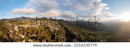 Greece, mountain village Kosmas aerial panoramic view, Peloponnese. Traditional tile roof and stone wall buildings, forest trees, cloudy blue sky, Autumn