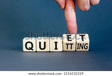 Quiet quitting symbol. Concept words Quiet quitting on wooden cubes. Businessman hand. Beautiful grey table grey background. Business quiet quitting concept. Copy space. Royalty-Free Stock Photo #2216532229