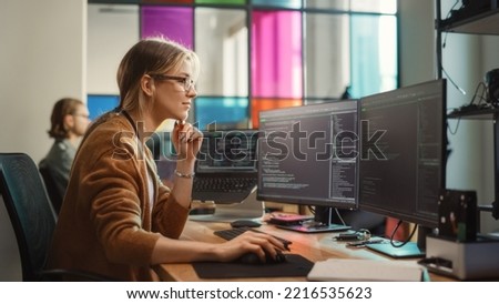 Female Software Engineer Writing Code on Desktop Computer with Multiple Screens Setup in Coworking Office Space. Professional Caucasian Woman Working on SaaS Platform For Innovative Startup. Royalty-Free Stock Photo #2216535623