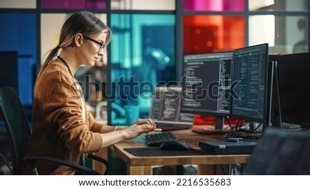 Young Caucasian Woman Programming On Desktop Computer With Two Monitors Setup in Spacious Office. Female Software Developer Creating SaaS Platform For Businesses in Innovative Start-up Company. Royalty-Free Stock Photo #2216535683