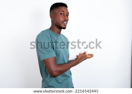 young handsome man wearing green T-shirt over white background Inviting to enter smiling natural with open hands. Welcome sign.