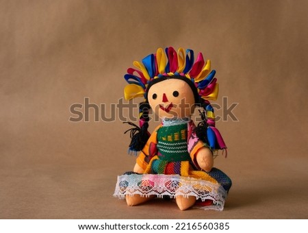 Colorful traditional Mexican doll, handmade by a member of an ethnic group called "Otomies". doll with braids and precious ribbons. Royalty-Free Stock Photo #2216560385
