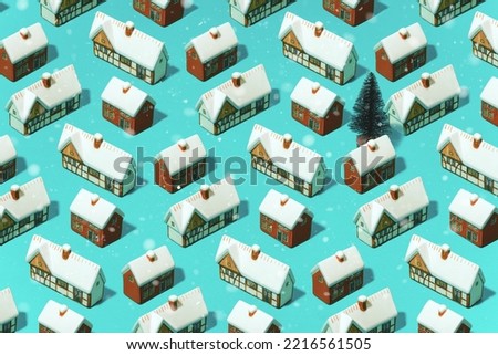 Trendy minimal pattern of different snow-covered houses on a pastel blue background