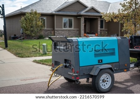 Winterizing a residential irrigation system by using a compressor and forced air to blow the lines empty. Royalty-Free Stock Photo #2216570599