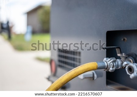 Winterizing a residential irrigation system by using a compressor and forced air to blow the lines empty. Royalty-Free Stock Photo #2216570607
