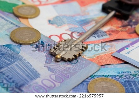 Money to buy an apartment. Paper cash and coins of the Republic of Kazakhstan. The key to the apartment in the mortgage. Rented accommodation during the holidays. Moving to a new house. Relocation
