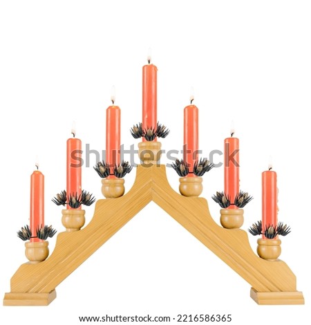 seven red burning wax candles on a wooden candlestick isolated on a white background