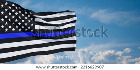 American flag with police support symbol Thin blue line on blue cloudy sky.