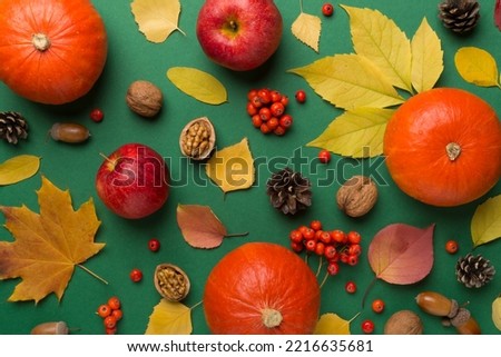 Festive autumn flat lay with pumpkins, berries and leaves on color background, top view.
