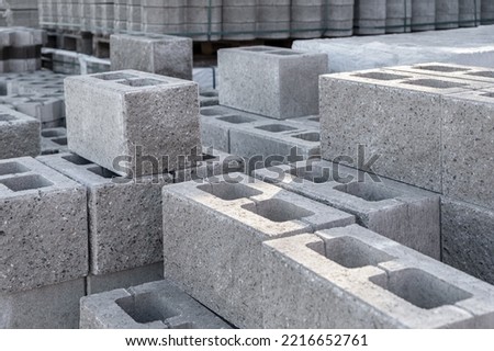 Pallet of Concrete Cinder Blocks, Grey Uniformed brick Shapes building material. New for use on construction site in europe Royalty-Free Stock Photo #2216652761