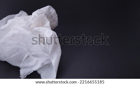 A used tissue on a black background.