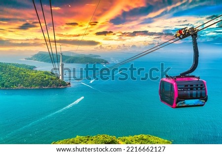 View of longest cable car ride in the world, Phu Quoc island, Vietnam, sunset sky. Below is seascape with tropical islands and boats. Royalty-Free Stock Photo #2216662127