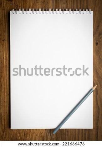 notebook with pencile on a wood background